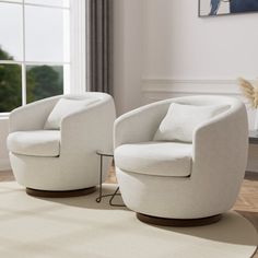 two white chairs sitting next to each other on a rug in front of a window