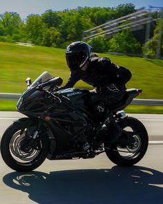 a man riding on the back of a black motorcycle