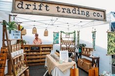 a man standing in front of a booth at a craft fair with lots of items on display