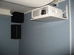 a white projector mounted to the side of a wall