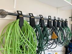 several cords are hanging on the wall with hooks