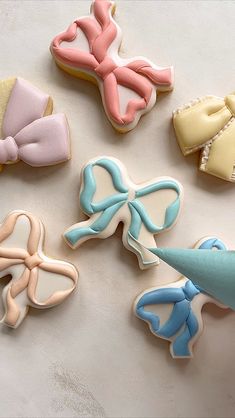 decorated cookies with bows and ribbons on a white counter top, ready to be eaten