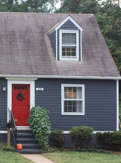 a small blue house with a red door