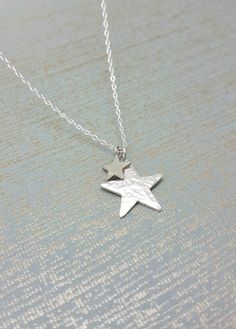 Sterling silver necklace with two star charms, the larger star is finished in a hammered effect Which catches and reflects the light, and the smaller one is polished to a high shine. All elements are 925 sterling silver. Large star measures 2cm (20mm) Small star 8mm. This comes on a delicate sterling silver chain, 16 or 18 inch please select when ordering. All Karmasilver Jewellery is handmade in the UK using traditional silversmithing techniques. Hammered moon & Star necklace https://www.etsy.c Cheap Silver Necklaces With Star Charm, Affordable Silver Star Charm Necklace, Silver Star Necklace, Long Stone Necklace, Honeycomb Necklace, Handmade Silver Jewellery, Star Necklace Silver, Silver Choker, Bridesmaid Necklace