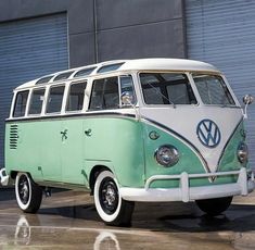 a green and white vw bus parked in front of a building