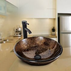 a bathroom sink sitting on top of a counter in front of a refrigerator freezer