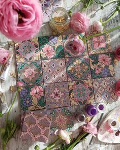 pink flowers are sitting on the table next to some crafting supplies