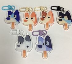 six popsicle shaped keychains with different designs on them, each featuring a dog's face