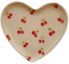 a heart shaped dish with cherries on it