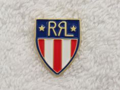 a red, white and blue badge with the word r & l on it's side