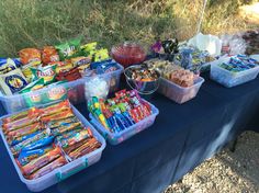 a table topped with lots of different types of snacks and candy bar containers next to each other