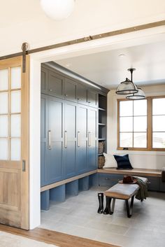 a room with blue cabinets and a bench