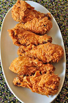 three pieces of fried chicken on a white plate