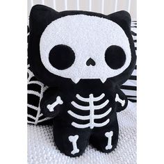 a black and white stuffed animal with a skeleton on it's back, sitting next to a crib