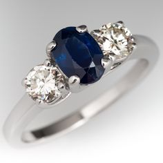 three stone diamond and blue sapphire ring in white gold with diamonds on the sides,