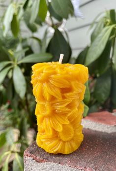 a yellow candle sitting on top of a cement block