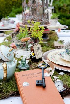 a table topped with lots of plates and a cross on top of moss covered ground