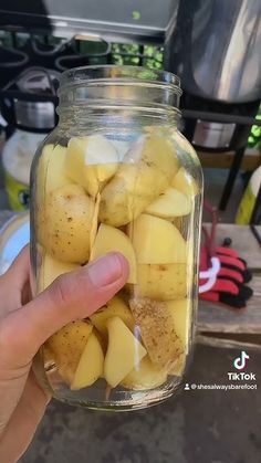 someone is holding up a jar full of potatoes