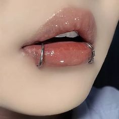 a woman's lips are covered in glitters and has a ring on her lip