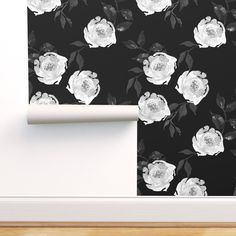 a black and white floral wallpaper with roses on it, next to a door