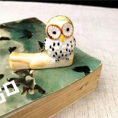 an owl figurine sitting on top of a book