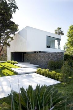 the modern house is surrounded by greenery and trees