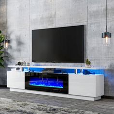 an entertainment center with a large television on it's side and a plant in the corner