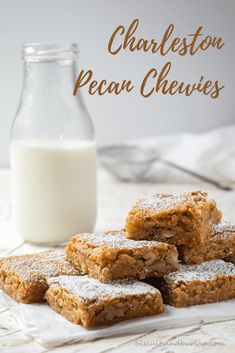 several pieces of dessert sitting on top of a table next to a glass of milk