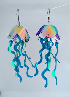 Twotone Jellyfish Earrings  These shimmery cuties are our bestsellers! Playful and vibrant, they sparkle and dance as hard as you do! A variation of the classic, this listing is for a custom made pair in whatever two colors you desire! The primary color will be applied to the body, the secondary color will be the tendrils. Length: approx 13cm (including earring hook) Width approx 3.5cm Price is for a pair (message me about mix and match colors/single earrings) Earring hooks are nickel free and h Unique Iridescent Earrings For Party, Whimsical Iridescent Earrings With Ear Wire, Whimsical Blue Earrings For Party, Handmade Iridescent Earrings For Party, Jellyfish Jewelry, Jellyfish Earrings, Iridescent Earrings, Ocean Earrings, Match Colors