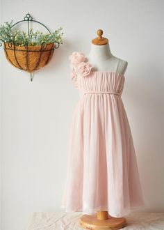 a dress on a mannequin next to a planter with flowers in it