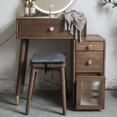 a wooden desk with a mirror and stool next to it