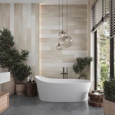 a large white bath tub sitting in a bathroom next to two plants and a window