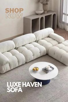 a large white couch sitting on top of a carpeted floor next to a table