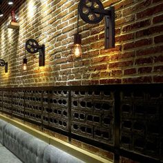 a brick wall with several lights on it and some benches in front of the bench