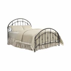 an iron bed frame with white sheets and ruffled bedspread