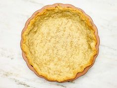 an uncooked pie crust on a marble counter top