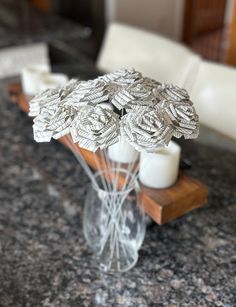 a vase filled with white candles sitting on top of a counter