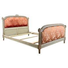 an antique style bed frame with pink upholstered pillows and headboard, on white background