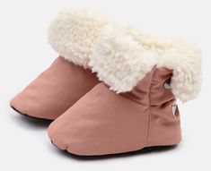 a pair of pink baby shoes with white fur on the top and bottom, side view