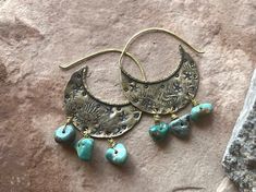 "Swoon! These ooak shield hoops have been hand fabricated using solid brass. These hoops have been heavily textured and stamped with various shapes and tiny stars. Mashan turquoise beads dance along the bottom of these earrings, giving them so much movement! Hammered brass ear wires have been soldered to the tops. Lightweight on the ears. Ready to ship! Xo MATERIALS: Brass, brass wire & Mashan Turquoise beads MEASUREMENTS: Approx 2\" L x 1 1/4\" W These will arrive gift wrapped in an eco friendly box." Rustic Patina Jewelry For Festival, Artisan Stamped Brass Jewelry, Artisan Brass Hoop Earrings, Artisan Brass Earrings With Patina, Handmade Rustic Brass Jewelry, Rustic Hammered Brass Jewelry, Soldered Turquoise Brass Earrings, Turquoise Soldered Brass Earrings, Artisan Hand Forged Hoop Earrings