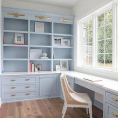 a chair sitting in front of a desk with bookshelves and drawers on it