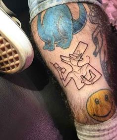 a man with a tattoo on his arm has a smiley face and an elephant in the middle