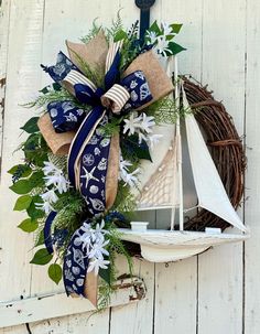 a wreath with a sailboat and flowers on it