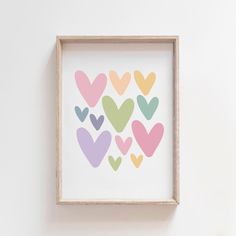 a wooden frame with hearts painted on it in pastel colors against a white wall