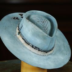 The perfect custom hat for standing out in a crowd! With its unique design and attention to detail, you'll be sure to turn heads and make a statement. Say goodbye to boring hats and hello to your new favorite accessory. DETAILS: - 100x Beaver western weight felt in light Blue - 4.5” crown - 3.5” flat style brim - Pinched crown - Fire distressed - Wood burned - Roan leather sweatband - Custom interior lining Handcrafted in FL USA Handmade Felt Hats, Sombrero Hat, Hats Collection, Handmade Hats, Timor Leste, Handmade Hat, Faroe Islands, French Polynesia, Tonga