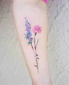 a tattoo with flowers on the arm and words written in cursive writing below it