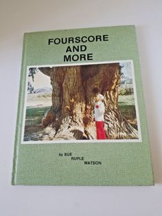 a book with an image of a person standing in front of a tree and the title four score and more