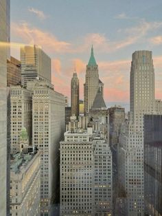 an image of the city skyline at sunset from high up in the building's windows