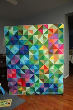 a large colorful quilt is on display in a room