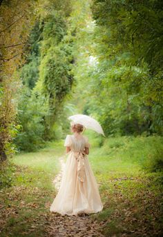 a woman with an umbrella is walking through the woods